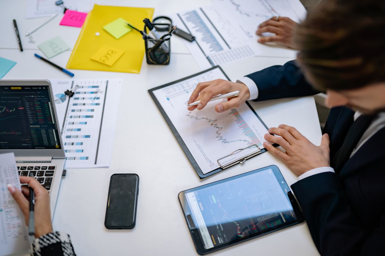 Équipe examinant des graphiques financiers et des données numériques sur des tablettes dans un bureau.