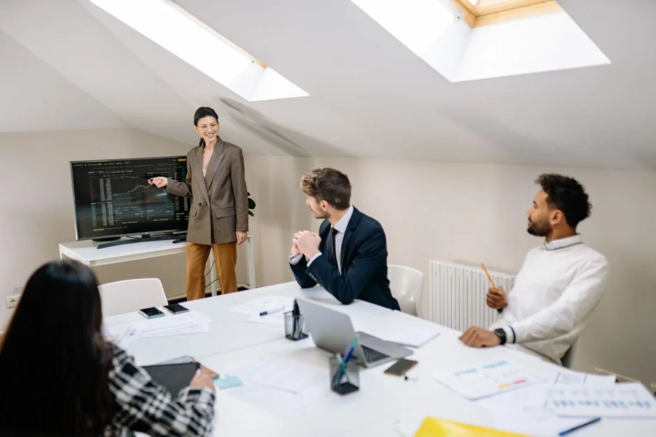 Un espace de travail moderne montrant des mains qui analysent des données marketing sur un ordinateur portable et des documents papier.